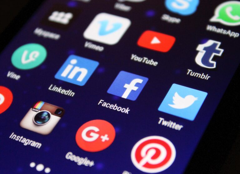 A smartphone screen displays various social media app icons, highlighting the diverse content types for social media across platforms like Facebook, LinkedIn, Twitter, Instagram, YouTube, Tumblr, Pinterest, WhatsApp, Vine, and Google+ on a dark background.