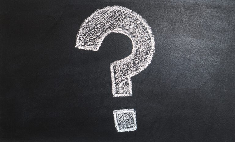 A large white question mark, drawn with chalk on a black chalkboard background, captures the curiosity essential for effective lead magnets in business.